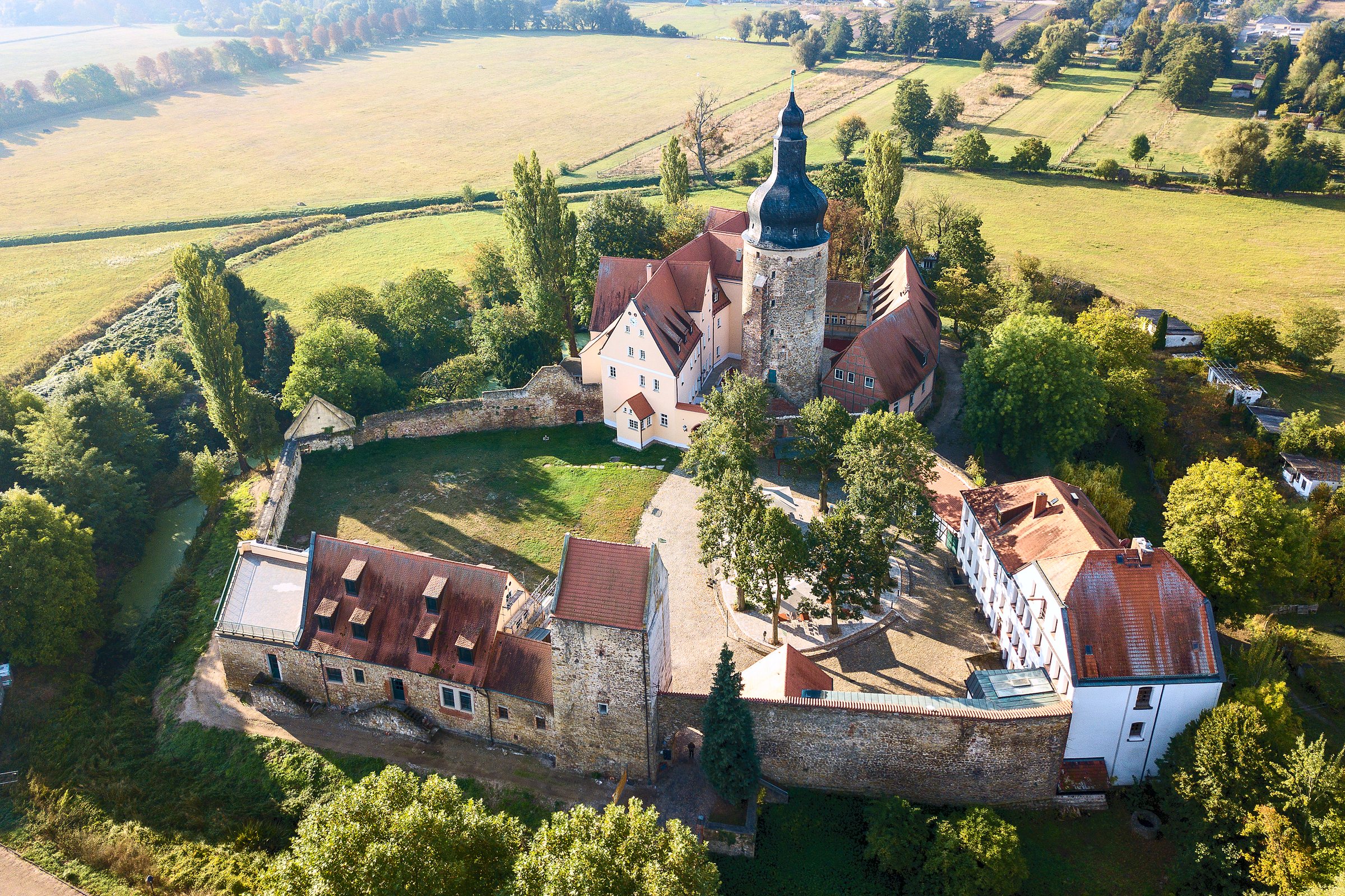 Wasserburg Gommern von oben mit gesamter Burganlage, Ringmauer und umliegenden Feldern